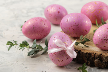 Obraz na płótnie Canvas Easter. Pink Easter eggs on a wooden stand on a light concrete background. Happy easter. holidays. close-up.