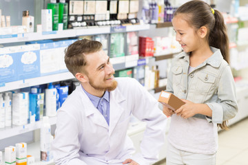 Fototapeta na wymiar Pharmacist helping little girl at the drugstore