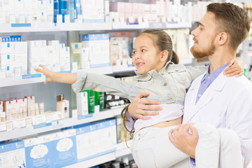 Fototapeta premium Pharmacist helping little girl at the drugstore