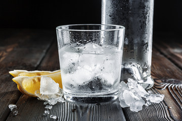 Vodka in shot glasses on rustic wood background