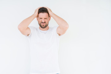 Young handsome man wearing casual white t-shirt over isolated background suffering from headache desperate and stressed because pain and migraine. Hands on head.