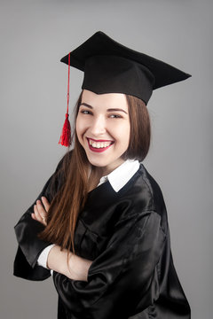 happy graduate in cap and graduation gown with diploma