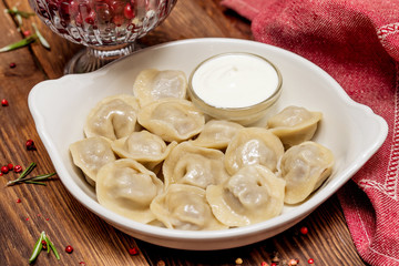 Dumplings with sour cream in a white plate