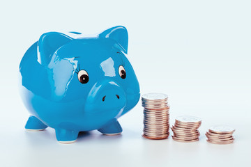 Pink piggy bank and coins isolated on white