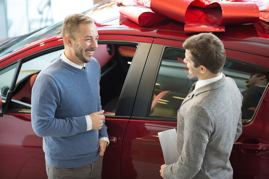 Male customer and car salesman at the dealership