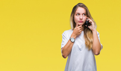 Young beautiful blonde woman calling using smartphone over isolated background serious face...