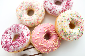 sweet food, junk-food and unhealthy eating concept - close up of glazed donuts on white table