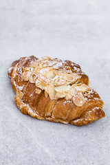 Fresh croissant with almond cream on white background. Close up