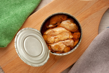 Canned cod liver. View from above. Cod fish liver in an open tin can. Cod fish liver closeup on a cutting board.