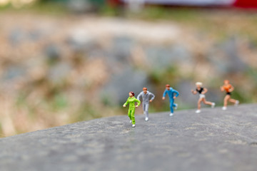 Miniature people Running on The Rock