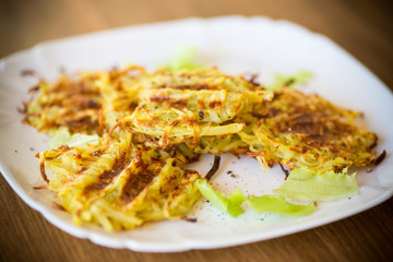 grilled potato pancakes in a plate, on a wooden table