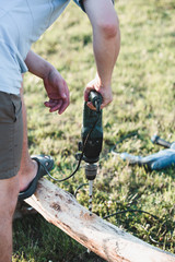 Obraz premium Man drilling hole in timber while working in garden
