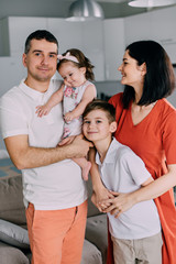 Fototapeta premium Young happy family in full standing at home