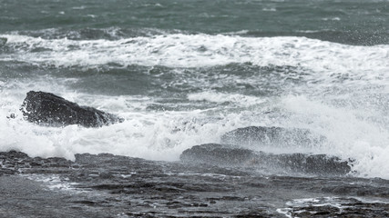 Splash of huge waves on a rocky shore