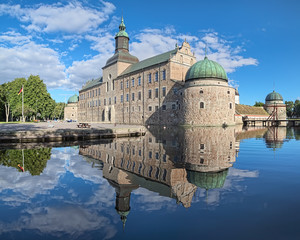 Vadstena Castle in the city of Vadstena, Sweden. The main castle building reflects in the water of...
