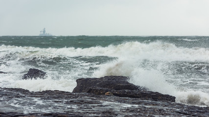 Splash of huge waves on a rocky shore