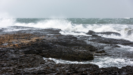 Splash of huge waves on a rocky shore