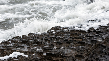 Splash of huge waves on a rocky shore