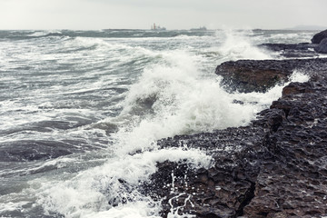 Splash of huge waves on a rocky shore