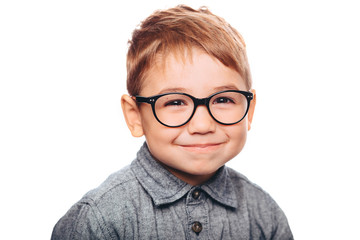 little boy with eyeglasses looking at camera on white background