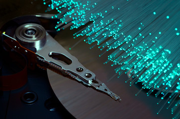 colored fiber optics over opened hard disk drive. abstract background