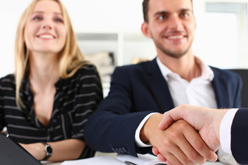 Man in suit shake hand as hello in office closeup