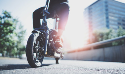 Naklejka premium Electric urban transportation.Young man ready to discover ride urban city by electric scooter. Wide. Flare.