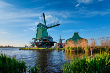 Fototapeta premium Windmills at Zaanse Schans in Holland on sunset. Zaandam, Netherlands