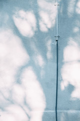 The texture of old white concrete. Sunlight and shadows on the wall.
