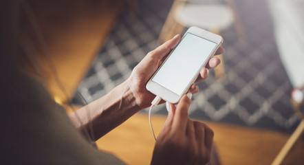 Female hands using mobile phone at sunny day in workplace.Horizontal. Blurred background
