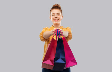 sale, outlet and people concept - smiling red haired teenage girl in checkered shirt with shopping...