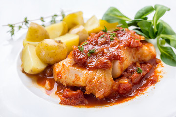 Plate of Cod or Pollack Stewed in Tomato and Thyme Sauce Garnished with Boiled New Potatoes