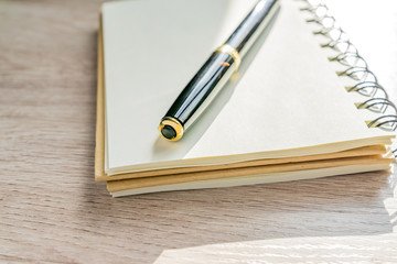 close up of empty kraft notebook and pen  on table background.