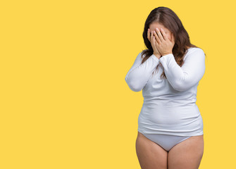 Beautiful plus size young overwight woman wearing white underwear over isolated background with sad...