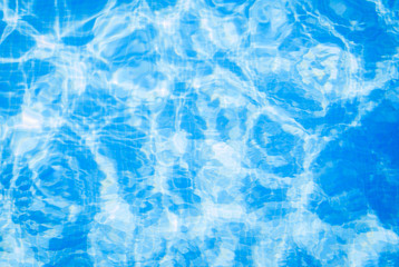 Closeup view of the swimming pool blue water surface copy space during a sunny summer day