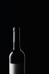 Glass wine bottle with blank label isolated on black