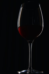 Glass of burgundy red wine isolated on black