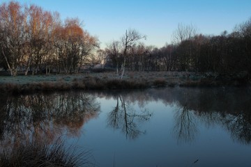 first light of sunrise reflected in a bedfordshire lake