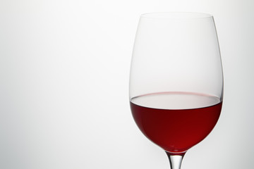 Wine glass with burgundy red wine on white