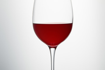 Wine glass with burgundy red wine on white