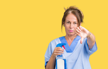 Middle age brunette cleaner woman wearing housework uniform over isolated background with angry face, negative sign showing dislike with thumbs down, rejection concept