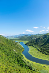 The picturesque meandering river flows among green mountains.