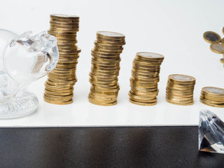A glass piggy, diamonds and coins towers background. Financial savings money for the future. Business investment and economical money concept.