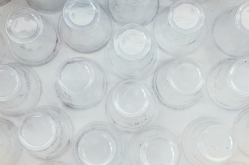 A lot of plastic cups, top view, white background. Increasing the amount of plastic concept. Non-compostable waste