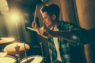 handsome drummer holding drum sticks and playing drums
