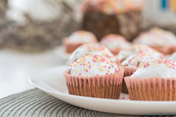 Easter muffins, cakes with confectionery on a white plate.