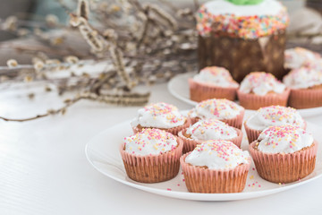 Easter muffins, cakes with confectionery on a white plate.