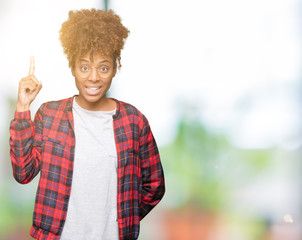 Beautiful young african american woman wearing glasses over isolated background pointing finger up with successful idea. Exited and happy. Number one.