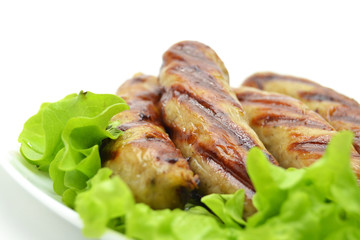 fried sausages and salad on a white plate