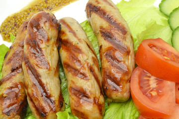 fried sausages and salad on a white plate